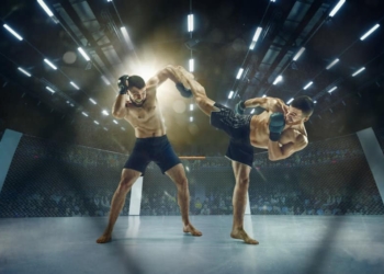 Ready to defend and attack. Two professional fighters posing on the sport boxing ring. Couple of fit muscular caucasian athletes or boxers fighting. Sport, competition and human emotions concept.