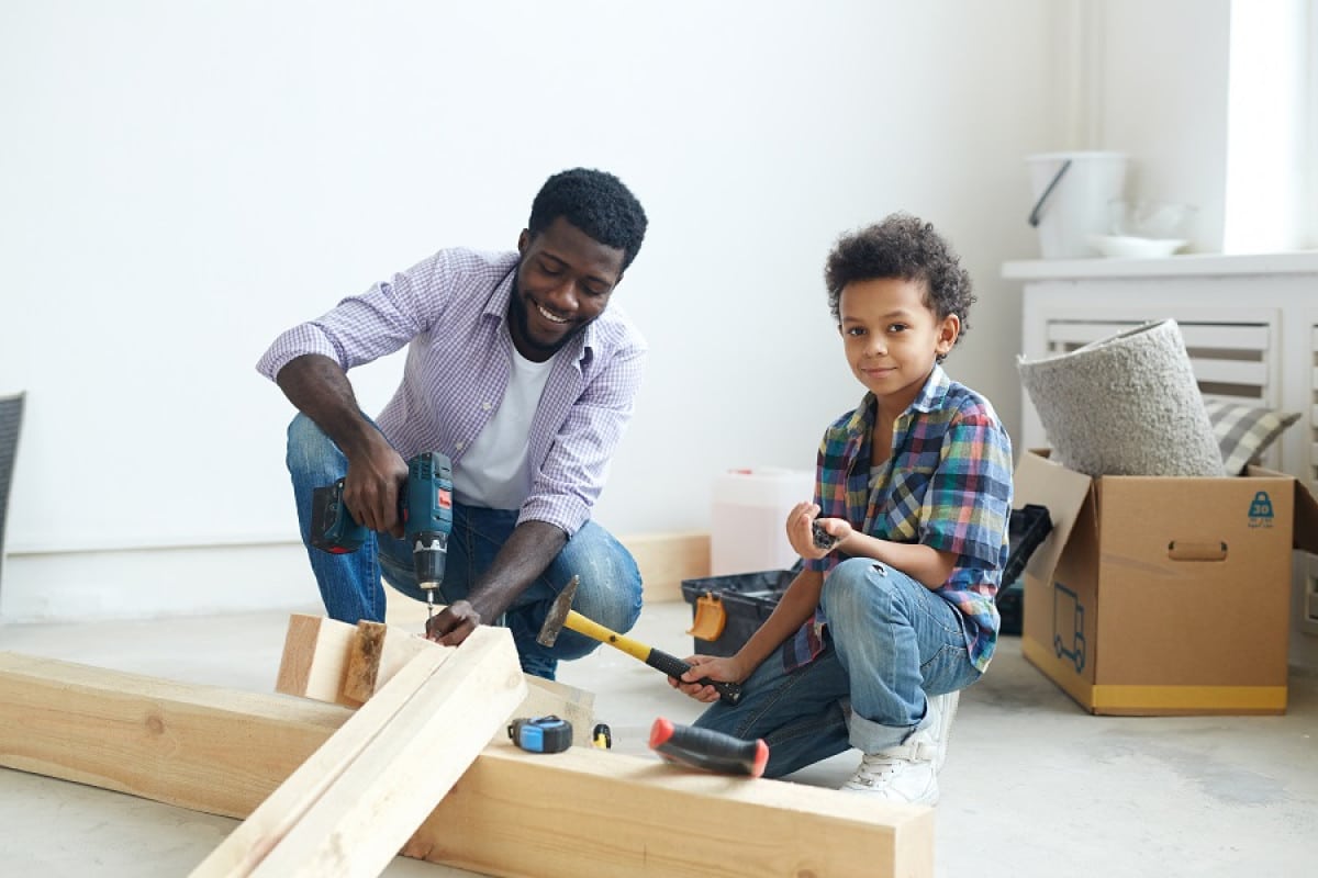 Père et fils réalisant des travaux dans la maison de vacances