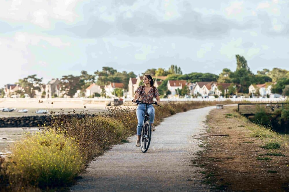 femme à vélo fleuve pont ville