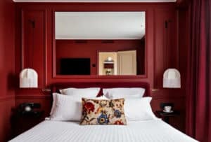 lit blanc et murs rouge de la chambre d'hôtel