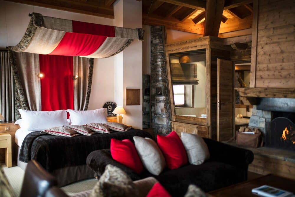 chambre spacieuse avec cheminée et coussins blancs et rouges