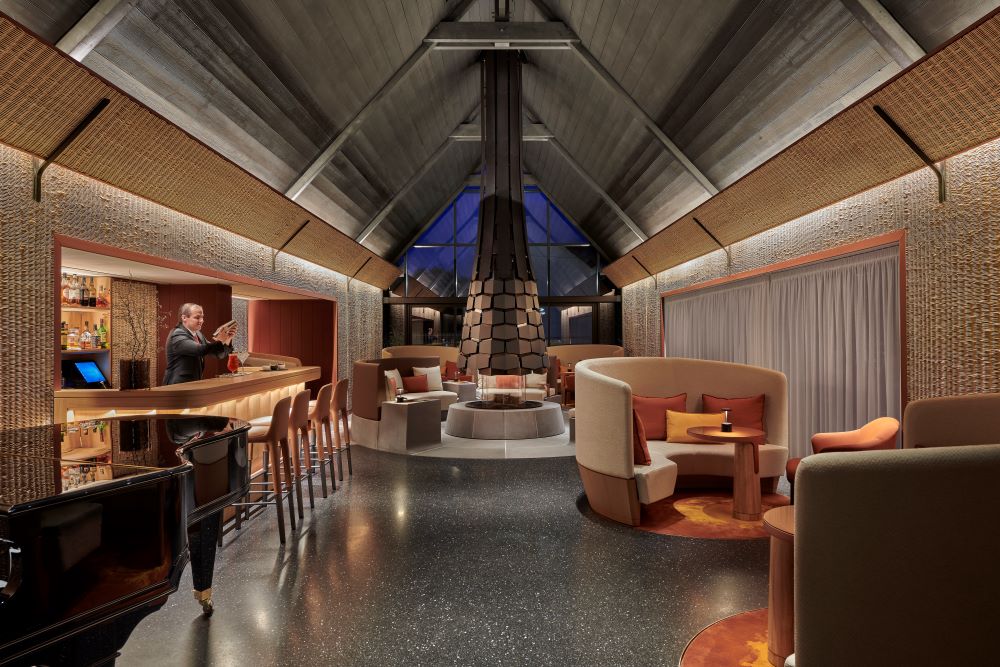 Salon cosy avec cheminée centrale et bar