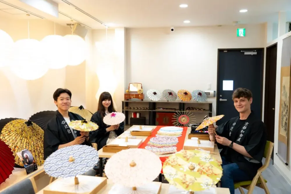 3 personnes autour d'une table à un atelier d'ombrelles