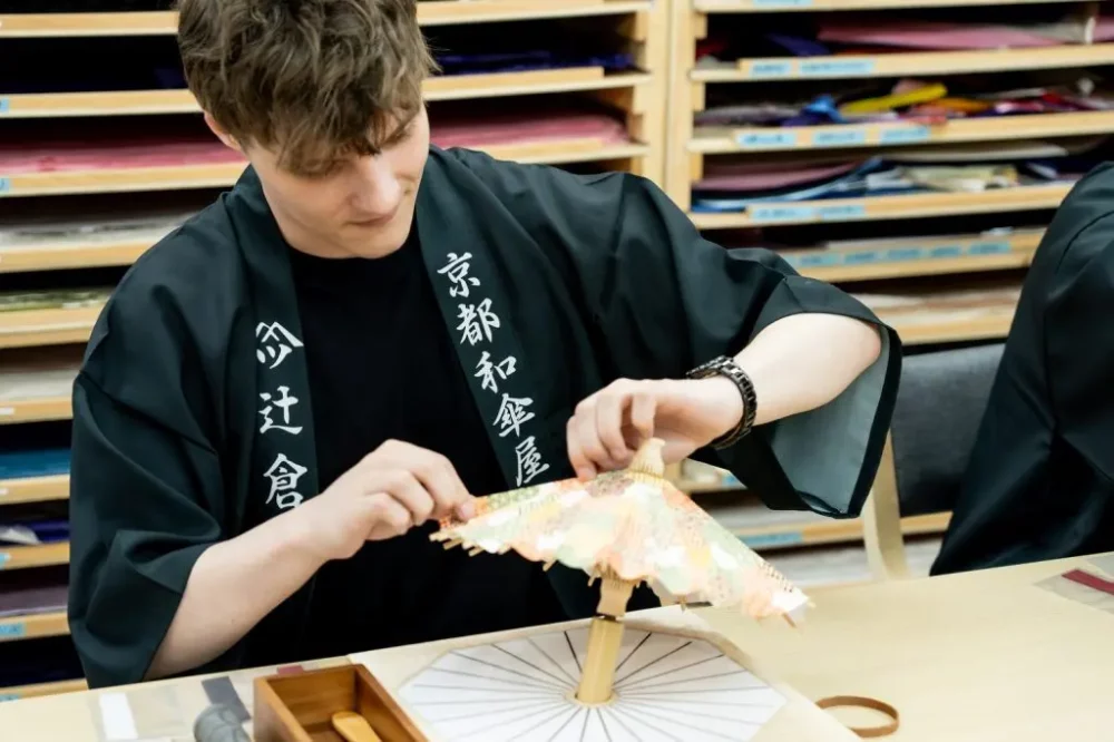 jeune homme fabriquant son ombrelle à un atelier japonais