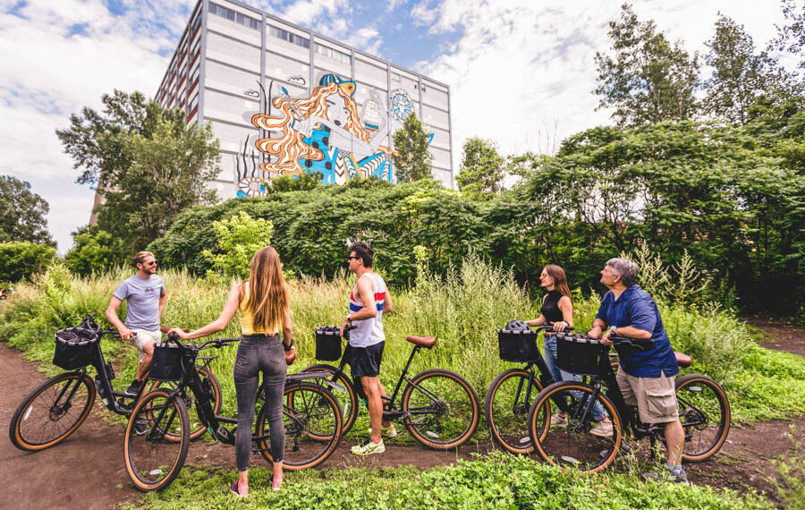 un groupe de personne à l'arrêt à vélos regardant un la fresque d'un bâtiment