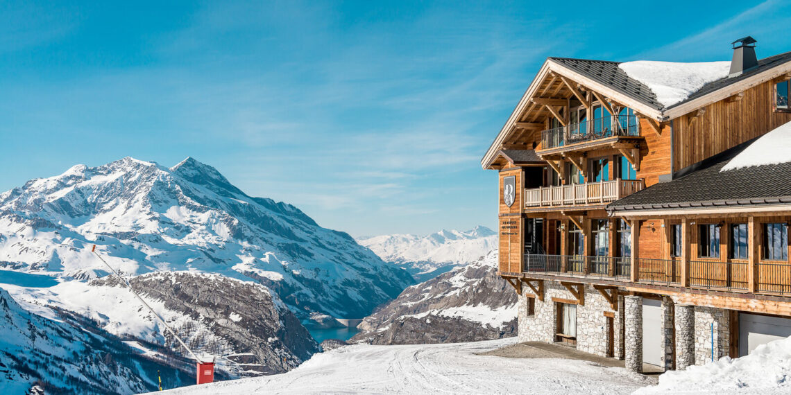 vue sur un chalet en bois dans les montagnes enneigées