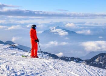 un skieur en rouge regardant le panorama de Flaine