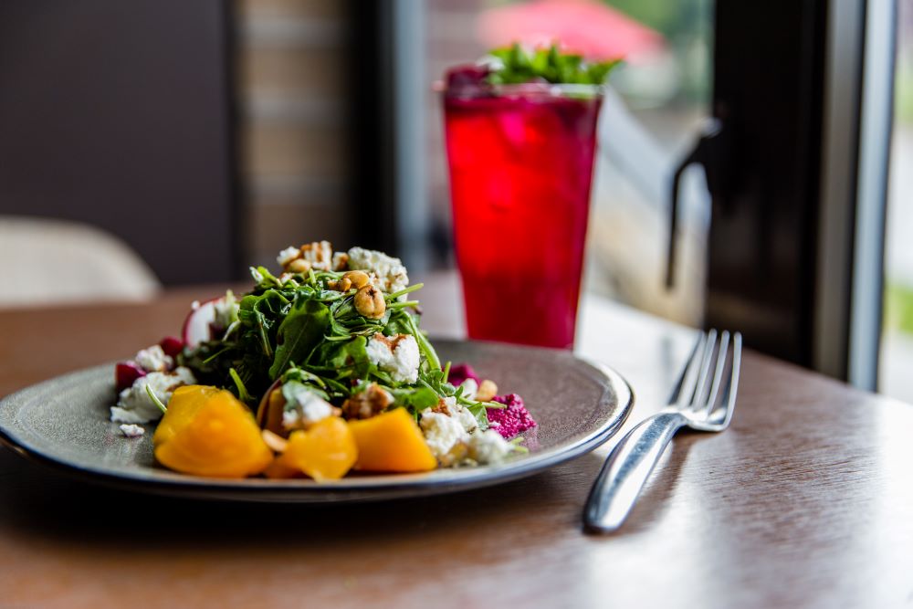 assiette de salade avec une fourchette et une boisson rouge