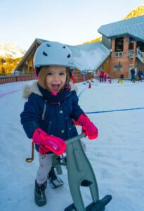 fillette en tenue de ski sur une snow draisienne