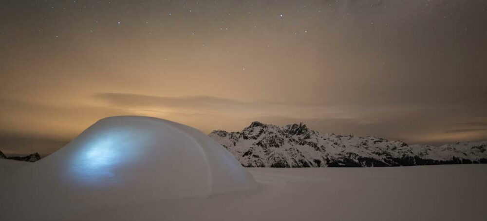 igloo éclairé la nuit sur la neige