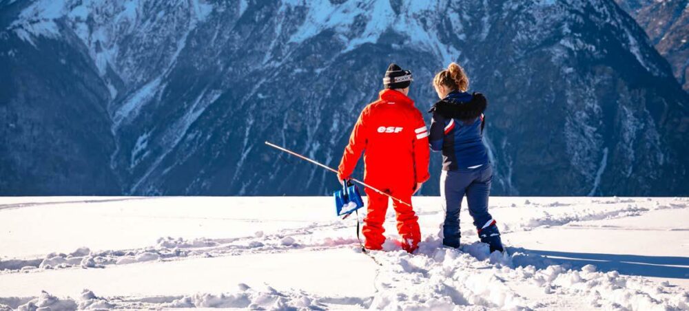 2 secouristes de dos dans la neige