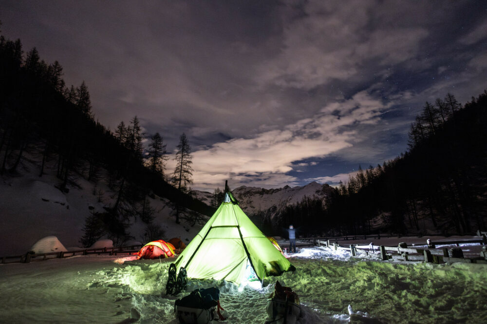 tente éclairée la nuit à la montagne