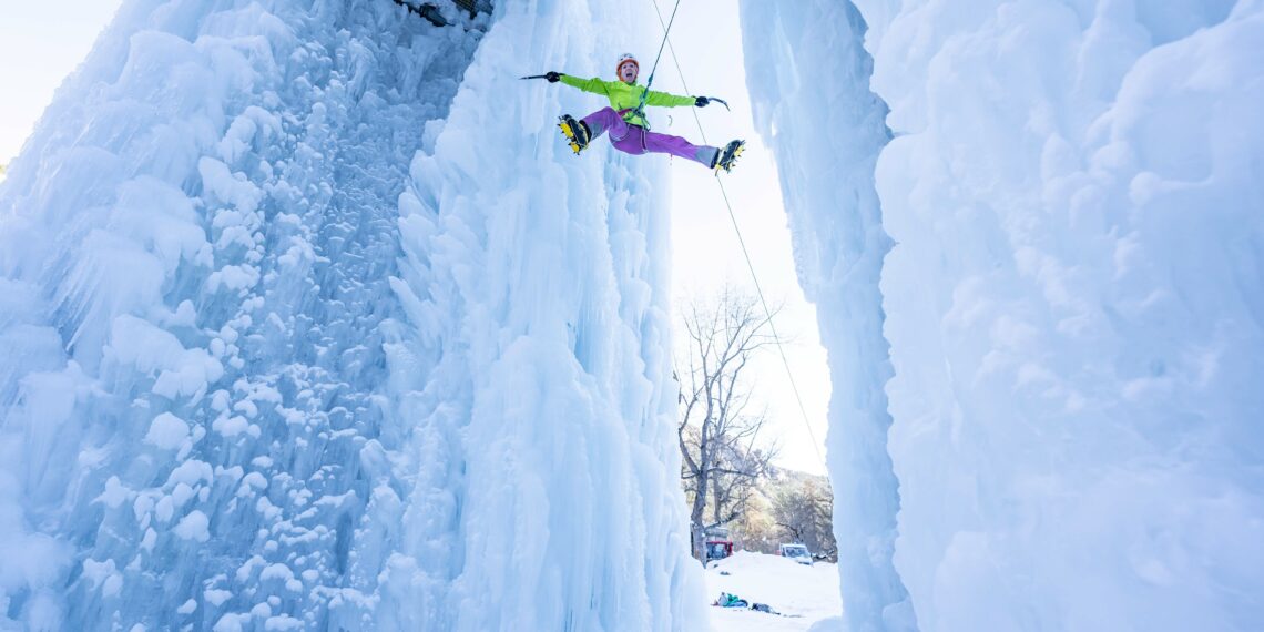 homme faisant de l'escalade dans une grotte de glace