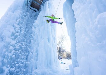 homme faisant de l'escalade dans une grotte de glace