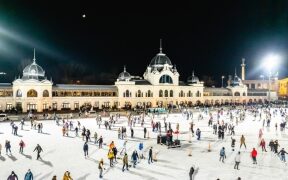 personnes faisant de la patinoire en extérieur devant un monument d'Hongrie