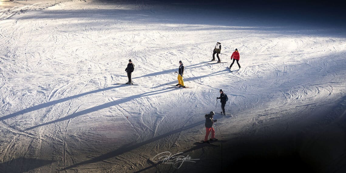 6 skieur vu de dessous sur un piste de neige blanche avec effets d'ombres et lumières