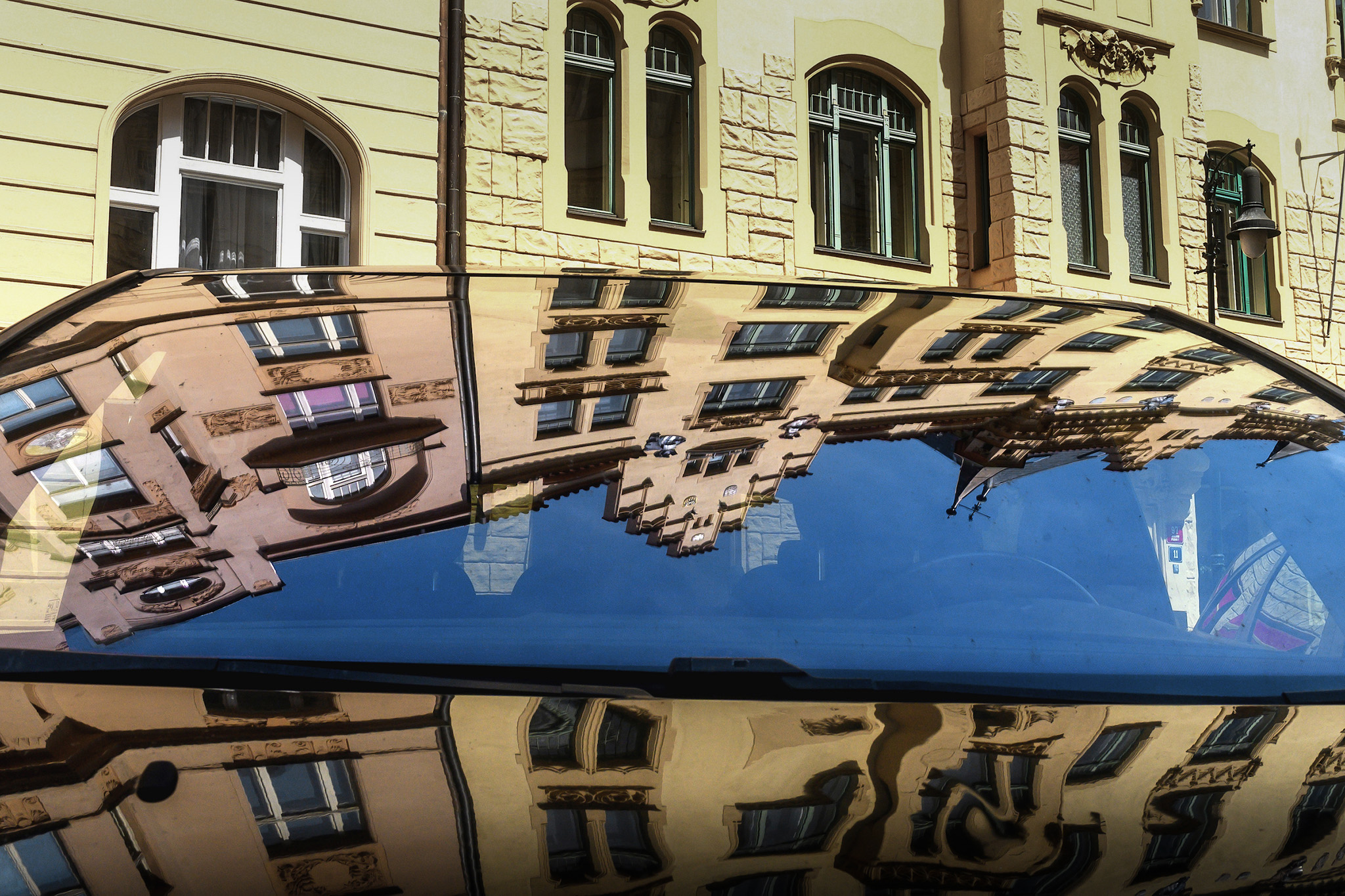 Photo de façade en reflet sur capot de voiture