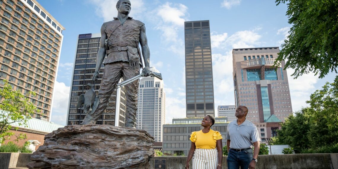 statue passants ville buildings