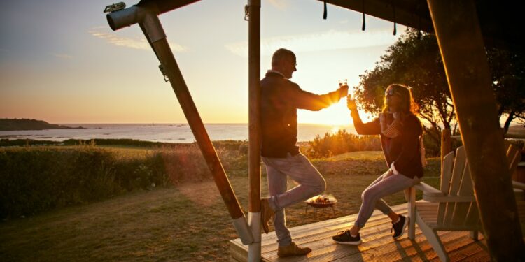 crépuscule plage homme et femme qui trinquent