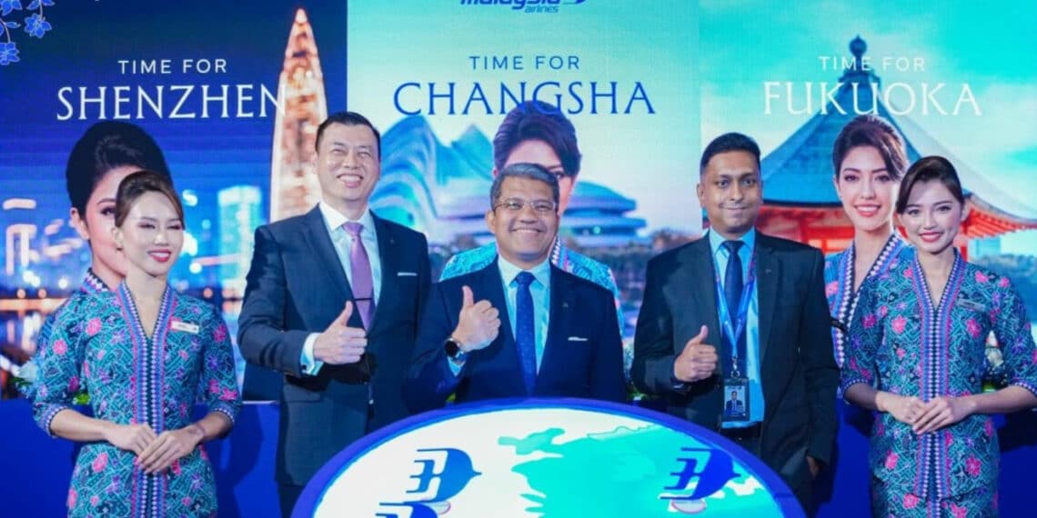 Hommes et femmes Malaysia Airlines pouces levés