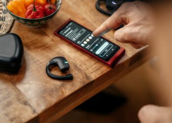 téléphone portable et écouteur posé sur une table en bois