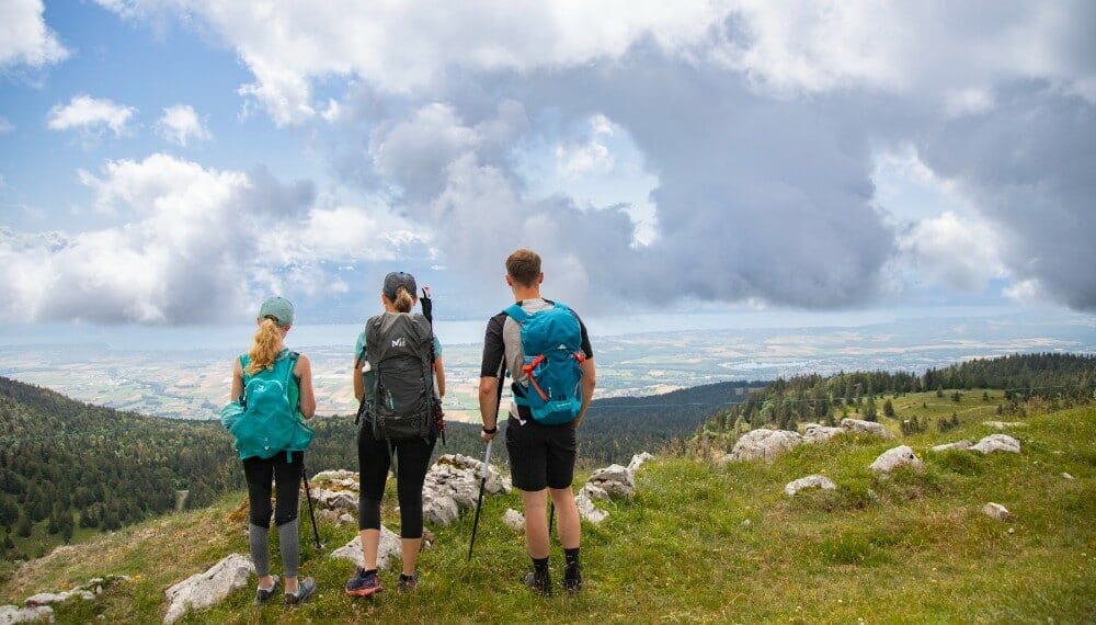 3 randonneurs de dos en haut d'une montagne