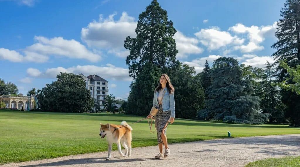 femme promenant son chien en laisse dans un parc