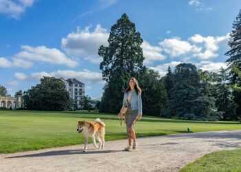 femme promenant son chien en laisse dans un parc