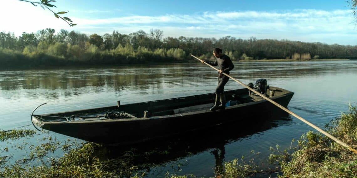 barque homme avec pagaie debout fleuve