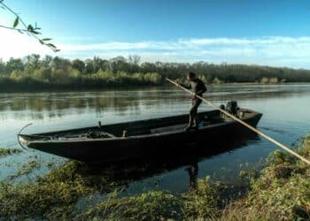 barque homme avec pagaie debout fleuve
