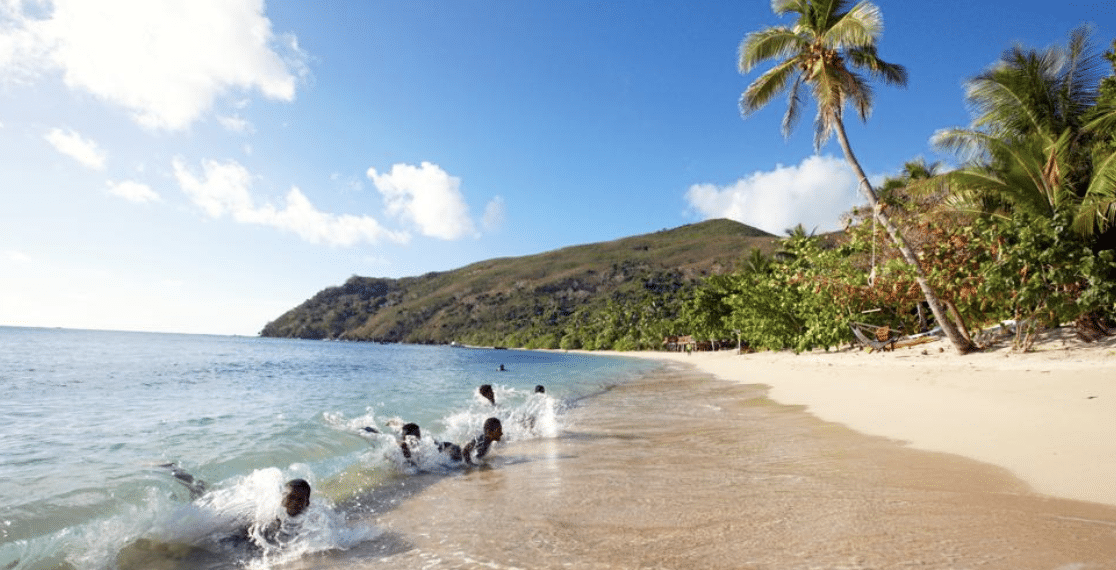 enfants se baignant dans la mer plage palmiers